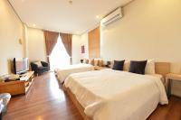 a hotel room with two beds and a television at Penghu Chenhi Bay Homestay in Baisha