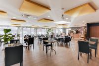 een restaurant met tafels en stoelen in een kamer bij ibis Montélimar Nord in Saulce-sur-Rhône