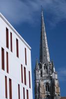 a tall building with a steeple next to a building at Temporesidence Cathedrale in Bayonne