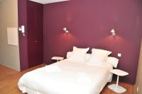 a bedroom with a white bed with a purple wall at Temporesidence Cathedrale in Bayonne