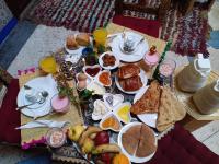 マラケシュにあるRiad dar Assouの朝食の食べ物と飲み物がいっぱいのテーブル
