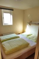 a bedroom with two beds and a window at Camping Bissen in Esch-sur-Sûre