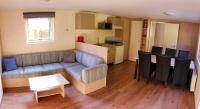 a living room with a couch and a table and a kitchen at Camping Bissen in Esch-sur-Sûre