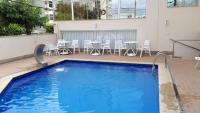 una piscina con sillas y una mesa en un edificio en Hotel Plenotel, en Colatina
