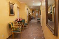 a hallway with a table and chairs and a mirror at Hotel Schlicker in Munich