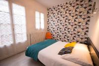 - une chambre avec un lit et un mur dans l&#39;établissement Hotel de Paris, à La Rochelle