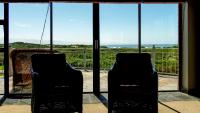 two chairs in front of a window with a view of the ocean at House Haven Guesthouse in Port Elizabeth