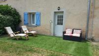 a yard with two chairs and a porch with blue doors at 926 Chemin de Saint-Antoine in Violès