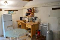 a kitchen with a desk and a refrigerator and a table at Gites Le Clos de Saires in Saires