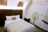 a bedroom with a bed with a tree on the wall at Lio Hotel - Taipei Main Station in Taipei