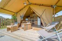 a tent with chairs and a table and a refrigerator at Gites Le Clos de Saires in Saires