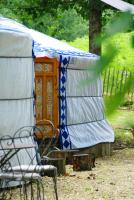 a yurt with a chair and a wooden door at Yourtes de Gascogne in Lannes