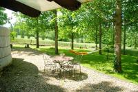 a table and chairs in a yard with a hammock at Yourtes de Gascogne in Lannes