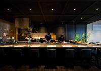 two people sitting at a bar in a kitchen at Hotel Sonia Otaru in Otaru