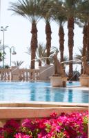 a swimming pool with palm trees and a fountain at Herods Palace Hotels & Spa Eilat a Premium collection by Fattal Hotels in Eilat