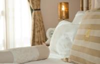 a white bed with white pillows and a window at Herods Palace Hotels & Spa Eilat a Premium collection by Fattal Hotels in Eilat