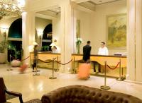 a man standing at a reception desk in a hotel lobby at Herods Palace Hotels & Spa Eilat a Premium collection by Fattal Hotels in Eilat