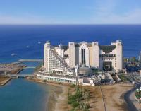 a large building on the beach next to the ocean at Herods Palace Hotels & Spa Eilat a Premium collection by Fattal Hotels in Eilat