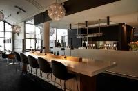 a bar with a long wooden table and chairs at Comwell Kolding in Kolding