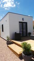 a house with a wooden deck with two potted plants at Au Cap Norwoe in Saint-Quentin-en-Tourmont