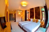a bedroom with a large bed and a table at Palm Leaf Resort Koh Tao in Ko Tao