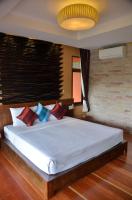 a bedroom with a large white bed with colorful pillows at Palm Leaf Resort Koh Tao in Ko Tao