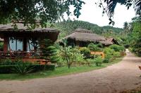 a house with a thatch roof and a road at Palm Leaf Resort Koh Tao in Ko Tao