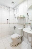 a white bathroom with a toilet and a sink at 日安艸木環境友善民宿 Greener Homestay in Taitung City