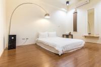 a bedroom with a white bed and a wooden floor at 日安艸木環境友善民宿 Greener Homestay in Taitung City