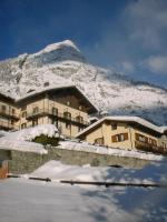 a building with a snow covered mountain in the background at Hotel Ottoz Meublé in Courmayeur