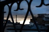 a view of the eiffel tower through a fence at Hôtel Plaza Étoile in Paris