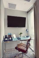 a room with a desk with a chair and a television at Artezen Hotel in New York