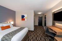 Una habitación de hotel con una cama grande y un televisor de pantalla plana. en Microtel Inn &amp; Suites by Wyndham Carlisle, en Carlisle
