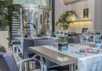 un restaurante con mesas y sillas con vasos. en Hotel La Bussola, en Milazzo