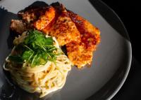 a plate of food with pasta and greens on it at Vila Europa in Struga