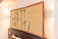 a large painting of palm trees on a wall at Kyoto Inn Gion The Second in Kyoto