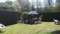 a small garden with a gazebo with flowers at AU BONHEUR in Idron
