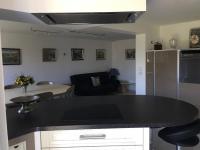 a kitchen with a black counter top and a living room at AU BONHEUR in Idron