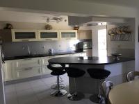 a kitchen with a black counter and stools in it at AU BONHEUR in Idron