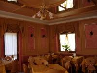 uma sala de jantar com mesas, cadeiras e janelas em Albergo Eden em Ponte di Legno