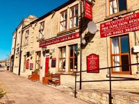 Un edificio con letreros en una calle. en The Old Post Office Public House &amp; Hotel, en Halifax