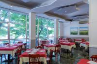 een restaurant met rode tafels en stoelen en ramen bij Hotel Plaza con piscina in Cattolica