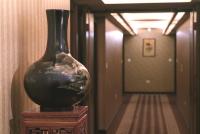 a black vase sitting on a stand in a hallway at King&#39;s Town Hotel in Kaohsiung