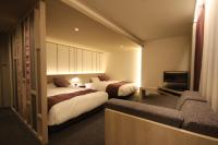 una habitación de hotel con dos camas y un sofá en Kita Hotel, en Morioka