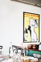 a dining room table with a picture of a cat on the wall at Plough Hotel in Melbourne