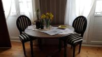 a wooden table with two chairs and a table with flowers on it at Au Nid de la Madeleine in Gaillac