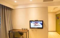 a room with a table and a tv on the wall at Just Live Inn-Taipei Station in Taipei