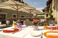 フォンテヴロー・ラベイにあるLogis Hotel La Croix Blanche Fontevraudの白いテーブルクロスと傘付きテーブル