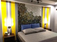 a bedroom with a bed with yellow and white stripes at Baan Baimai Boutique Room in Phra Nakhon Si Ayutthaya