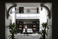 a man walking through a living room with a couch at Liu Men Melaka in Melaka